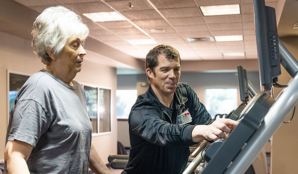 Personal Trainer Brian showing Wilma the treadmill settings